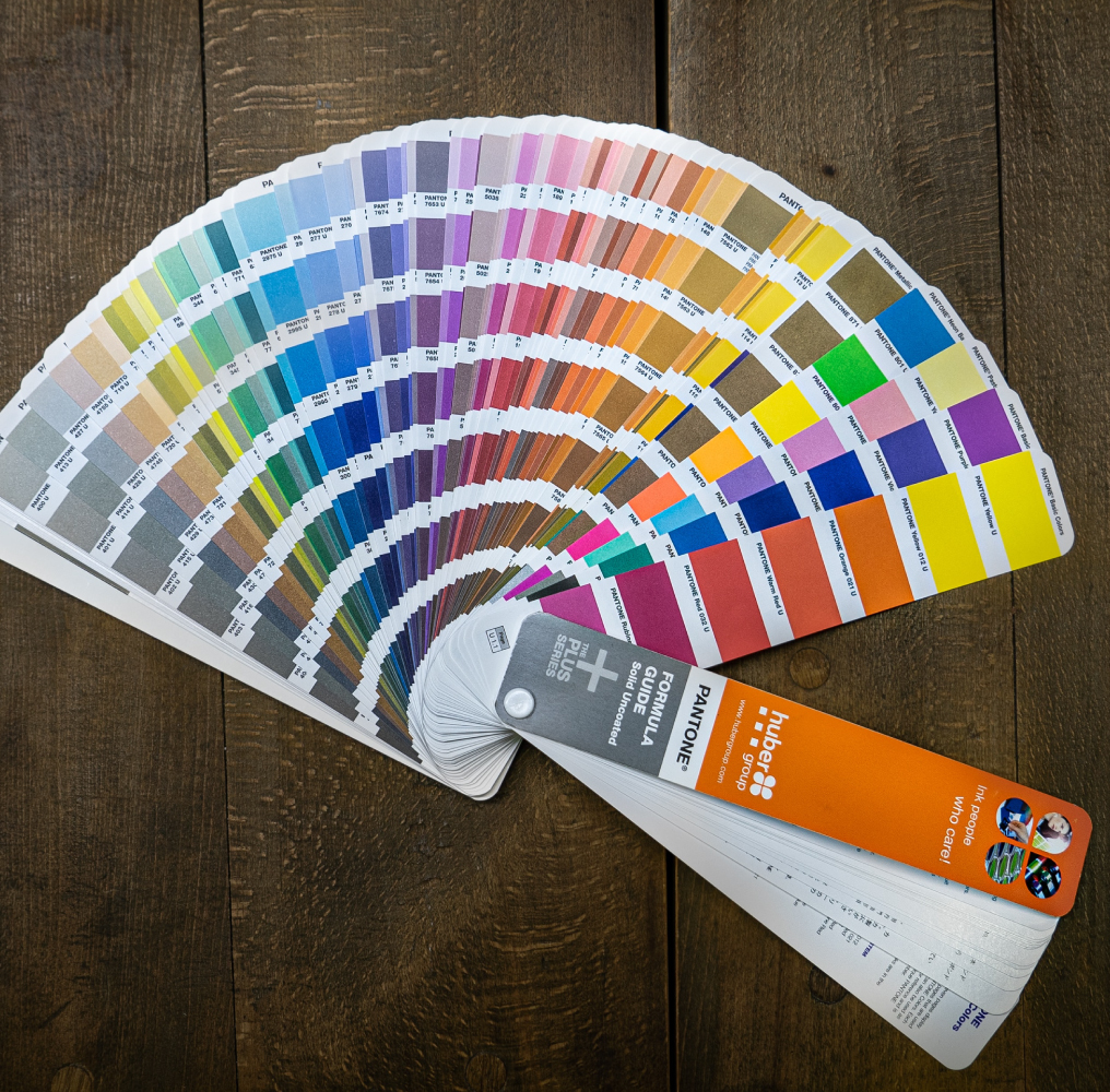 Pantone Color Formula Guide Spread Out on Wooden Table