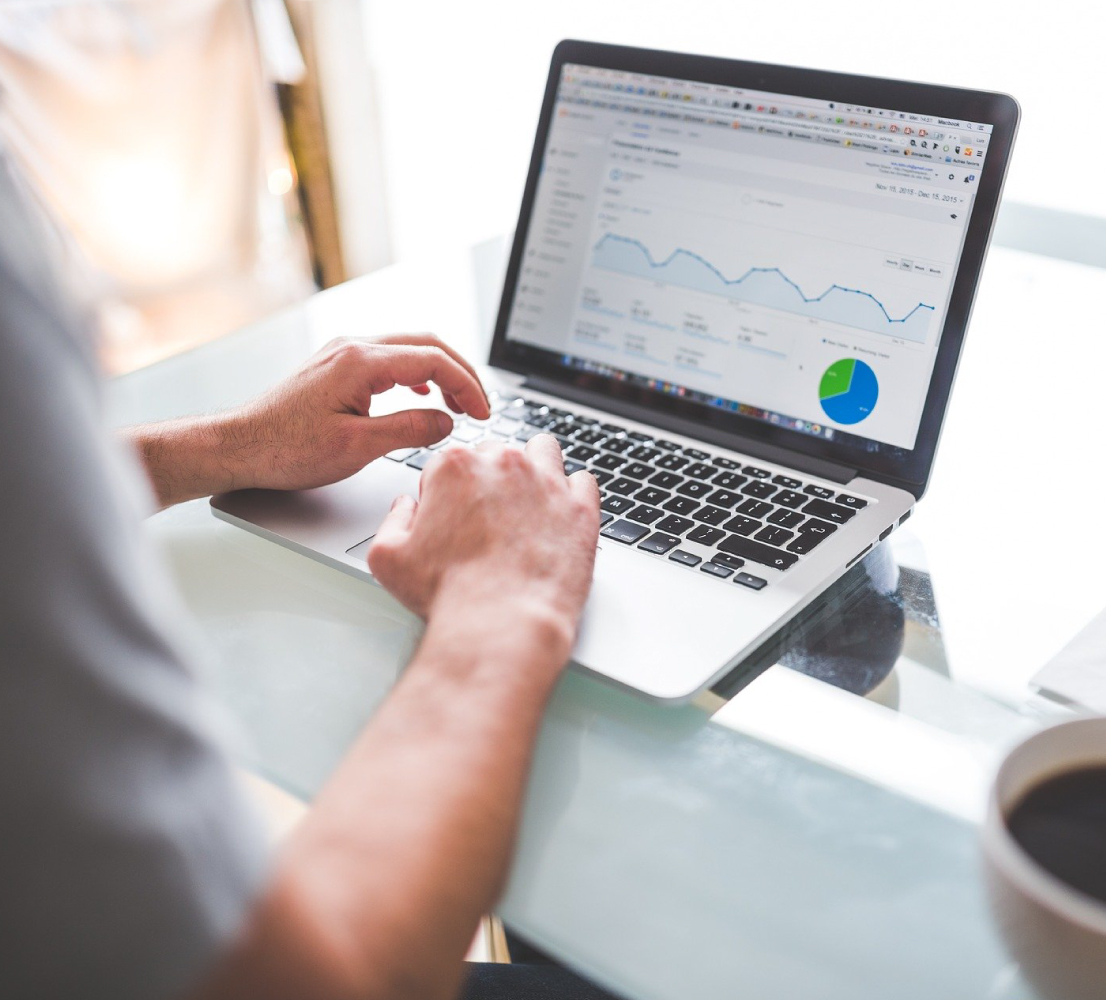 Man's Hands on Laptop Keyboard, Google Analytics Reports on Screen