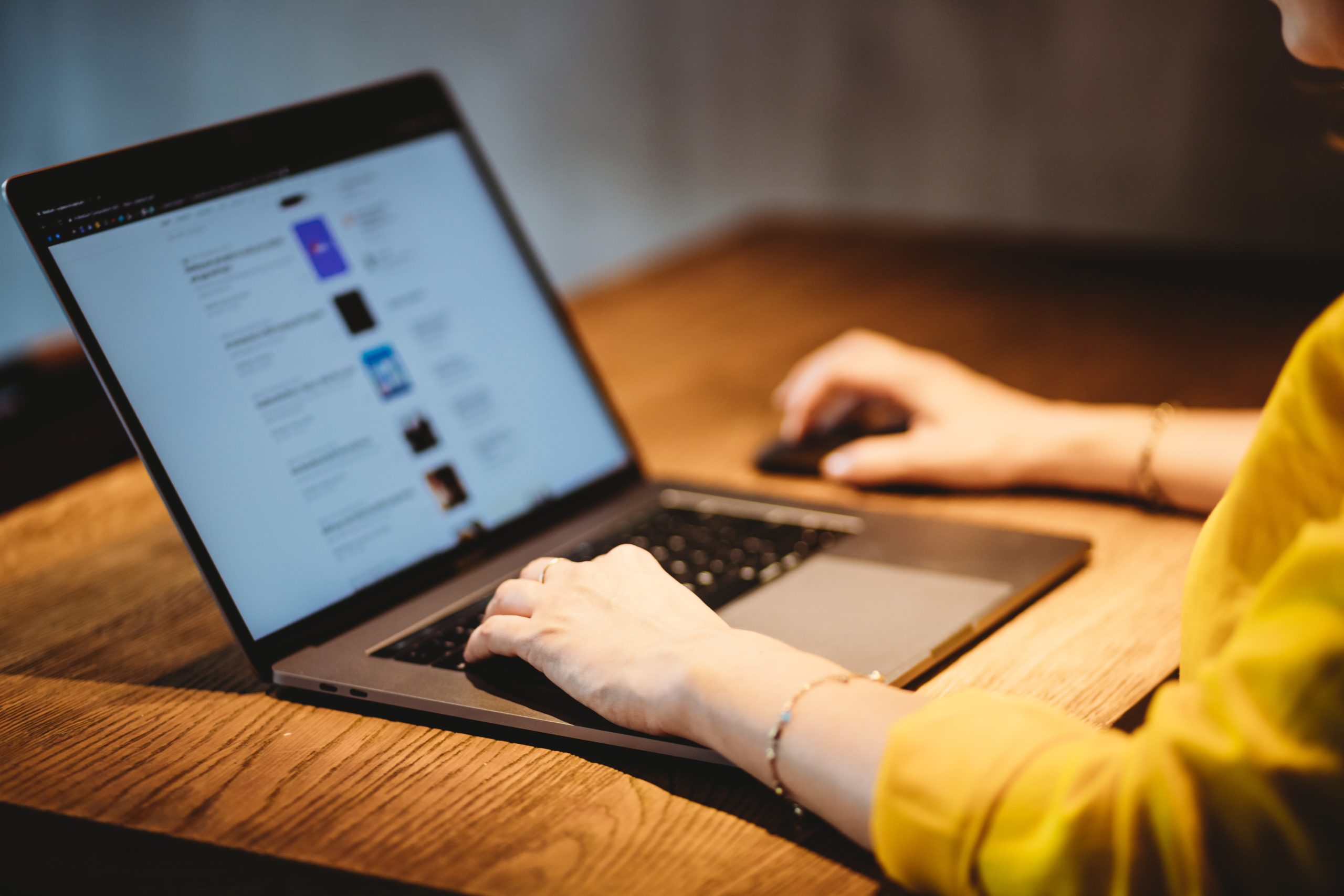 Woman with hands on MacBook Pro Keyboard, Screen Displaying SEO Google Search Results