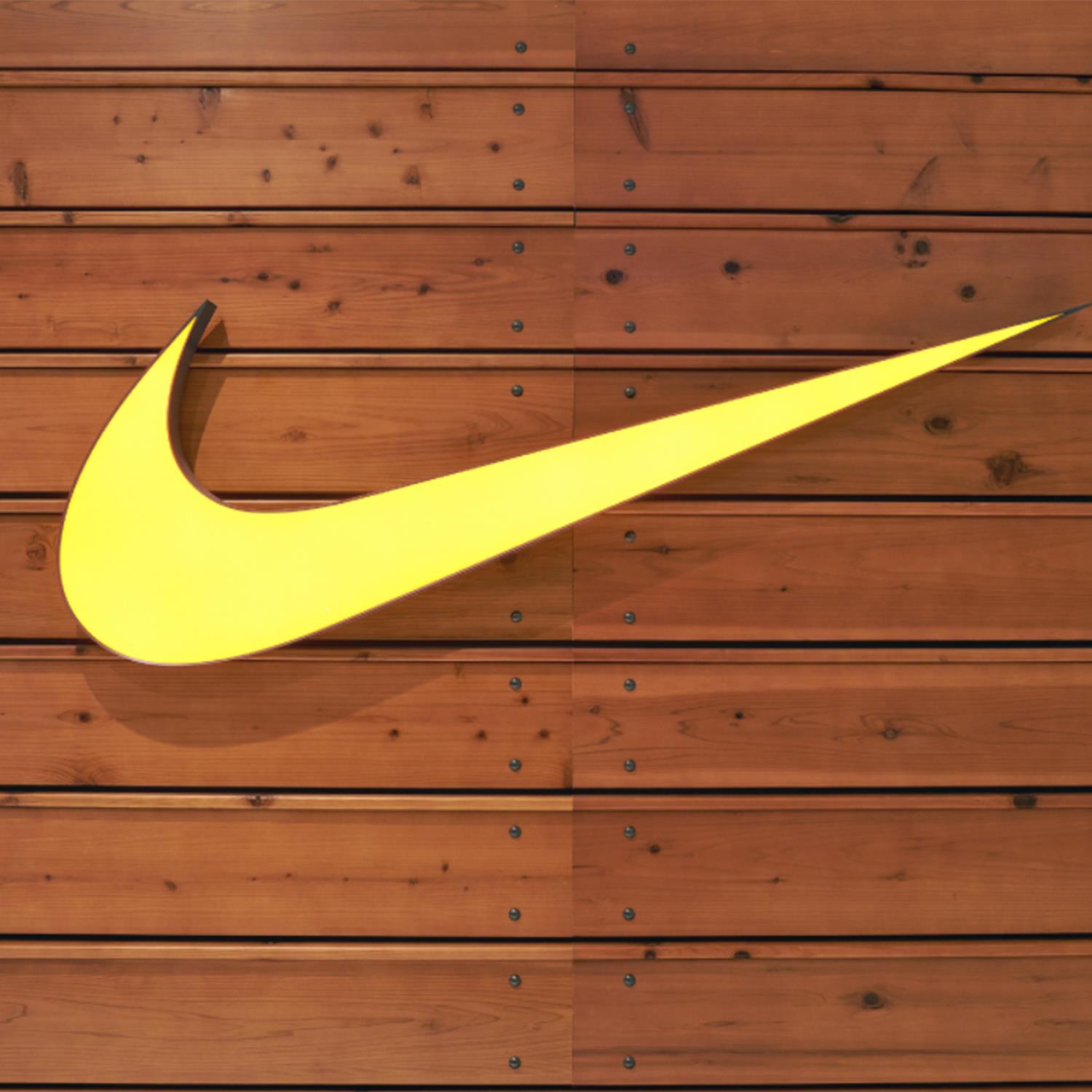 Yellow Nike Swoosh on Wooden Wall