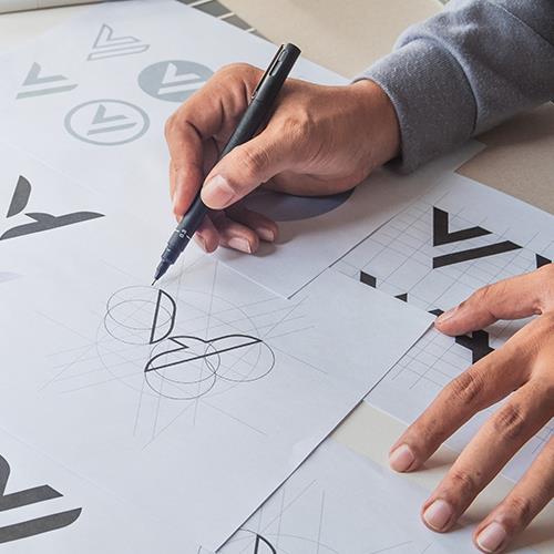 Close Up of Man's Hands Drawing Logo Designs