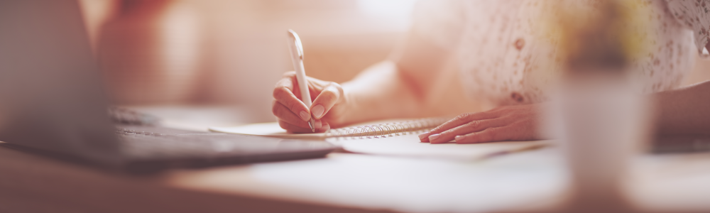 Woman writing in notebook at the office