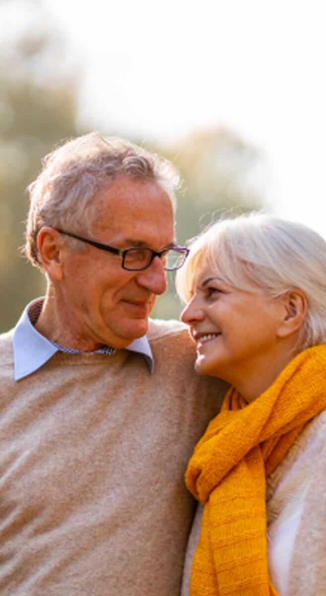 Two Older Adults Smiling, Looking at One Another